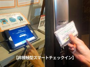 a person holding up a electronic device in front of a machine at WE HOME HOTEL and KITCHEN 市川 船橋 in Ichikawa