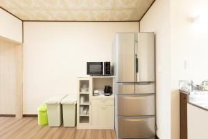 a kitchen with a stainless steel refrigerator in a room at Guest House 来夢 in Otaru