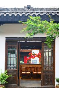 an open door of a building with benches in it at Mount Emei Heyuan Serene Residence Hot Spring Hotel in Emeishan City