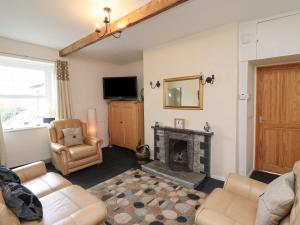 a living room with a fireplace and a television at Budle Bay Cottage in Bamburgh