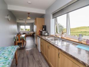 a kitchen with a counter with a sink and a window at Budle Bay Cottage in Bamburgh