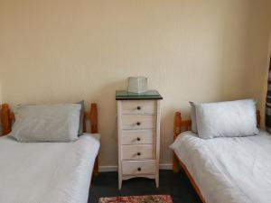 a bedroom with two twin beds and a dresser at Budle Bay Cottage in Bamburgh