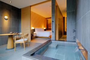 京都ROKU KYOTO, LXR Hotels & Resorts的带浴缸的浴室和卧室