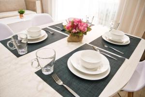 une table avec des assiettes, des verres et un vase de fleurs dans l'établissement Seven sea jomtien by new, à Jomtien Beach