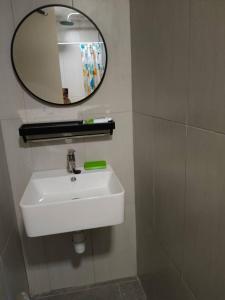 a bathroom with a white sink and a mirror at Humaira Dian Residency Studio Homestay 360sqft in Shah Alam