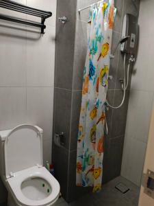 a bathroom with a shower curtain with a toilet at Humaira Dian Residency Studio Homestay 360sqft in Shah Alam
