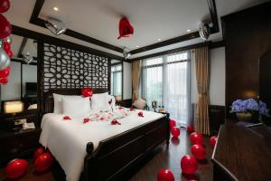 a bedroom with a bed with red balloons on it at MAY DE VILLE Crown Hotel in Hanoi