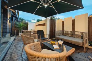 un patio con tavolo, sedie e ombrellone di Jingli Hotel Beijing Heshenghui Dajiaoting Subway Station Branch a Pechino