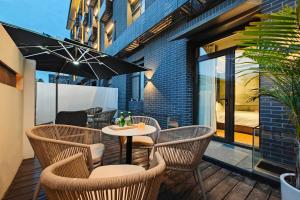 patio con sedie e tavolo con ombrellone di Jingli Hotel Beijing Heshenghui Dajiaoting Subway Station Branch a Pechino