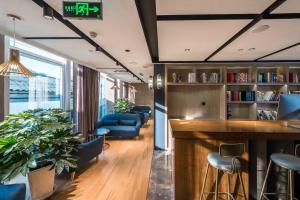 un bar in una biblioteca con sedie e tavoli blu di Jingli Hotel Beijing Heshenghui Dajiaoting Subway Station Branch a Pechino