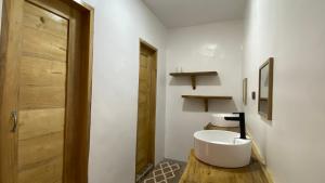 a bathroom with a white sink and a wooden door at MHARI Guest Rooms in San Juan