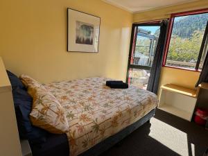 a bedroom with a bed and a window at Southern Laughter Backpackers in Queenstown