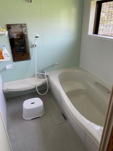 un bagno con una vasca bianca e un water di Guesthouse85BASE a Suo Oshima