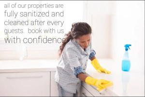 a woman is washing a counter in a kitchen at Cozy Motel Studio with kitchenette - 7 in Edmonton