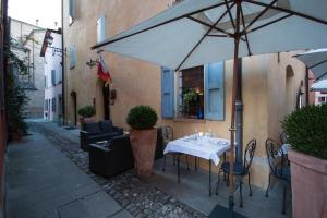 una mesa y sillas con una sombrilla en una calle en Locanda Del Feudo Suite & Restaurant en Castelvetro di Modena