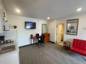 sala de estar con escritorio y sofá rojo en Cozy Motel Studio with kitchenette - 8, en Edmonton