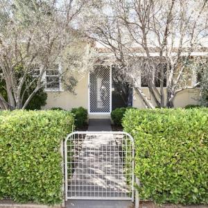 un portail devant une maison avec des buissons dans l'établissement Fitzroy Olive Cottage, à Dubbo