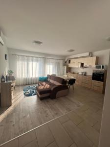 a large living room with a couch and a kitchen at Hegin Szigeti Apartman in Pécs