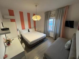 a small hotel room with a bed and a couch at F.Rooms Napoli in Naples