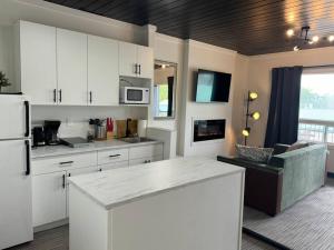 Una cocina con gabinetes blancos y encimera. en 1 BD Motel Condo with kitchenette - 10, en Edmonton 9 fotos más
