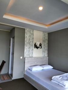 a bedroom with a large white bed and a window at Villa Paiton Bromo in Probolinggo +7 photos