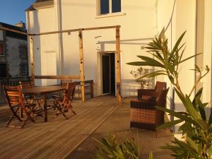 a wooden deck with a wooden table and chairs at La Moutonne des Landes de Lanvaux in Saint-Jacut-les-Pins