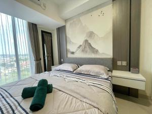 a bedroom with a large bed with a painting on the wall at PANORAMIC Apartment Units with VIEWS Managed by AIO Pollux Meisterdadt in Batam Center