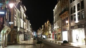 una calle de ciudad vacía por la noche con edificios en Hotel Le Splendid, en Troyes