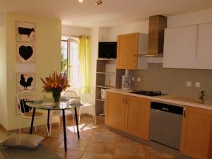 a kitchen with a table and a kitchen with a stove at Gîte les Platanes in Sainte-Hélène-du-Lac