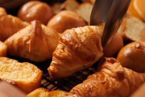 a pile of croissants are being cut with scissors at WeBase TAKAMATSU in Takamatsu