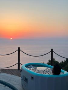 a person sitting in a bath tub overlooking the ocean at SECRET HILL in Athani