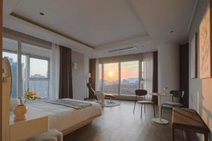a hotel room with a bed and a table and chairs at Le Collective Haeundae Paragraf in Busan