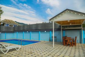 a patio with a pool and a table and chairs at A-Frame Villa in Gabala with Garden & FREE Airport shuttle in Gabala