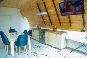 a kitchen with a table and a tv on the wall at A-Frame Villa in Gabala with Garden & FREE Airport shuttle in Gabala