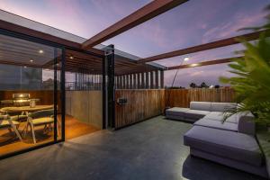 Un patio con un sofá y una mesa en una terraza. en Alex Villas Complex N2, en Canggu