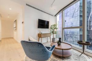 a living room with a chair and a table at Vibrant & Lively Condo with Stunning City Views in Melbourne