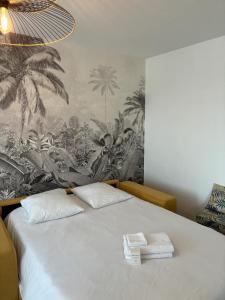 Un dormitorio con una cama con dos toallas encima. en Le Calme- Cosy, chaleureux - Parc de verdure, en Caluire-et-Cuire