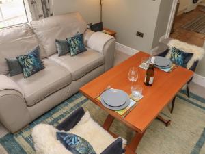 a living room with a couch and a table at Five Bells Cottage in Alnmouth