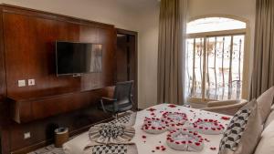a hotel room with a bed and a television at Milan Park Hotel in Taif