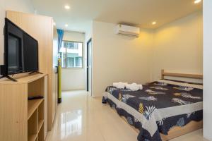 Un dormitorio con una cama y un televisor de pantalla plana. en Nice to meat you Rooms, en Patong Beach