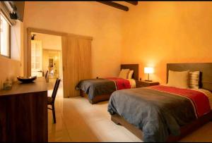 a bedroom with two beds and a desk and a mirror at Habitacion I Para 4 Personas 3 Camas in Morelia +8 photos