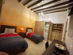 a bedroom with two beds and a desk and a table at Habitacion I Para 4 Personas 3 Camas in Morelia