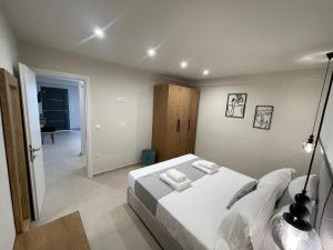 a bedroom with a white bed in a room at GeoMar Luxury Apartments in Skala Marion