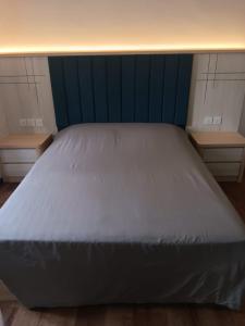 a large bed in a room with two tables at Star Regency 2 Rooms Apt, Brinchang Town in Cameron Highlands