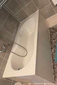 a white tub in a bathroom with a shower at Y Hoa-Ferienzimmer in Artern