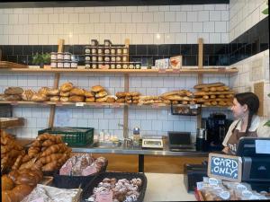 a woman standing behind a counter in a bakery at The City Palace - R.Q.C. in The Hague