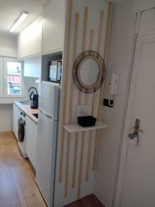 a kitchen with a refrigerator and a mirror on the wall at APARTAMENTO con ESTILO en el CENTRO -Stylish Apartment in the Center in Santander