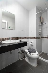 Un baño con inodoro, lavabo y espejo. en Nice to meat you Rooms, en Patong Beach