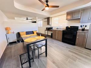 a large kitchen with a table and a ceiling fan at Super Loft ubicadísimo cerca Visas Hospital in Heroica Nogales