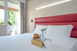 奥西莫戴克内罗皇宫酒店的卧室配有白色床和红色床头板